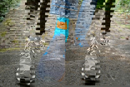 Person wearing bright cat socks and trainers